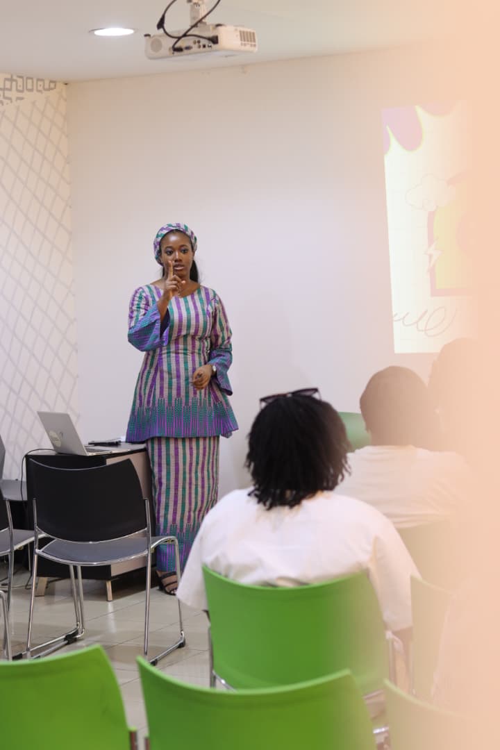 Jasmine-Jade presenting to an FCDC audience with a slide projected behind her