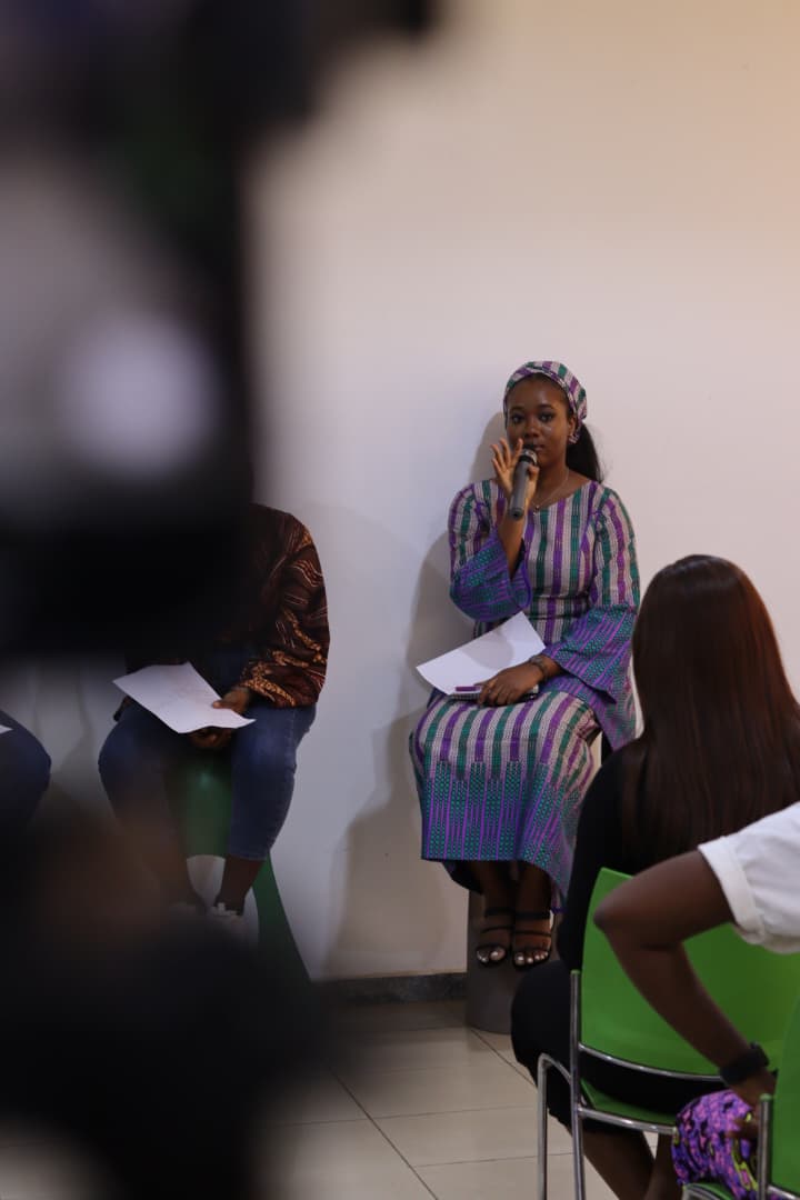 Jasmine-Jade speaking into a microphone on an FCDC panel